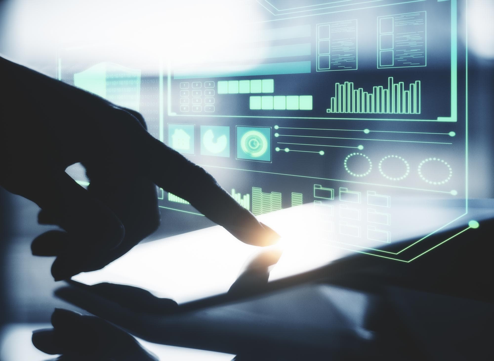 A hand touching a screen as process indicators light up on a data dashboard