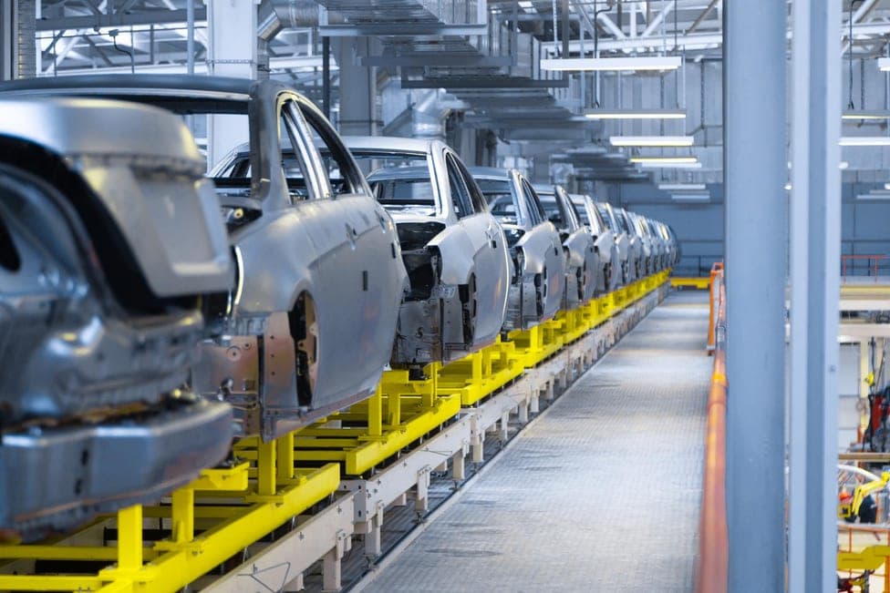 Car bodies moving in a row down an assembly line